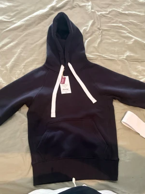 Mörkblå hoodie från Russemerch - En mörkblå hoodie från russemerch utan dragkedja, storlek Small unisex ,aldrig använd, lapparna sitter kvar, pris kan förhandlas vid snabb affär.