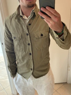 Olivgrön overshirt från closed  - Snygg olivgrön overshirt från closed med två bröstfickor och svarta knappar. Tillverkad i ett mjukt bomullstyg som ger en avslappnad look. Perfekt att bära över en t-shirt eller skjorta för en stilren och trendig outfit. Bra skick men olivgrön ”vintage” färg, storlek XS