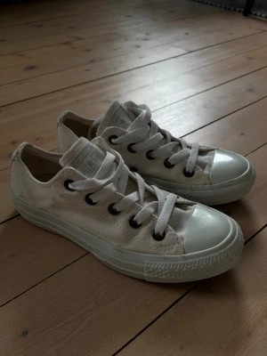 Vita låga Converse All Star sneakers  - Klassiska vita Converse All Star sneakers i tyg med vita snören och gummitå. Använda fåtal gånger. Pris kan diskuteras!