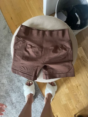 Bruna cykelshorts - Snygga bruna cykelshorts med bred, ribbad midja. Shortsen är stretchiga och sitter tight, perfekta för en sportig look. Tillverkade i mjukt bomullsmaterial som känns skönt mot huden.