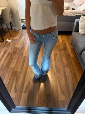 Ljusblå bootcut jeans med slitningar - Har sprättat upp de där nere men ser bara ut som en snygg detalj