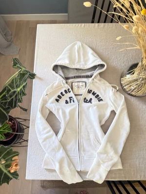 Vit hoodie från Abercrombie & Fitch - Vit hoodie med dragkedja från Abercrombie & Fitch. 