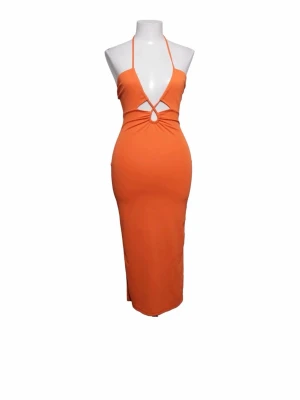 Orange långklänning med halterneck - Trendig orange långklänning med halterneck och snygg cut-out framtill. Klänningen har figurnära passform och knytning i nacken. Perfekt för dig som vill sticka ut med en färgstark look.