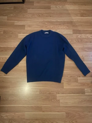 Blå stickad tröja - Storlek M och är lite ljusare i verkligheten än på bild