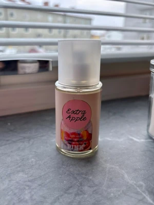 Extra Apple Body Mist parfym - Fräsch body mist parfym från Rituals med doft av äpple. Flaskan är genomskinlig med rosa etikett och motiv av äpplen. Praktisk sprayflaska med frostat lock, perfekt att ha med i väskan. 75 ml, se bild hur mycket som använts 
