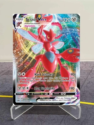 Pokémonkort Scizor VMAX  - Unikt Pokémonkort med Scizor VMAX från Sword & Shield-serien. Kortet är holografiskt med färgstark design i rött, blått och silver. Det har 320 HP och attacker som Hard Scissors och Max Steelspike. Perfekt för samlare eller dig som vill boosta din lek med en VMAX.