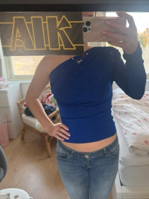 Blå oneshoulder topp - Snygg elegant blå oneshoulder topp med lång ärm på ena sidan💙toppen har ett väldigt skönt och stretchigt material. Nypris: 399kr. Använd en gång på nyår!