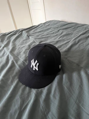 New era keps mörkblå - Säljer en super fin Mörkblå New era keps, använd endast fåtal gånger, säljes pga för stor storlek för mig. Storlek finns i en av bilderna, Nypris 530kr