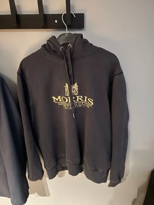 Morris Hoodie - En svart morris hoodie med stort tryck på framsidan. Den är storlek S men kan även massa lite större. 