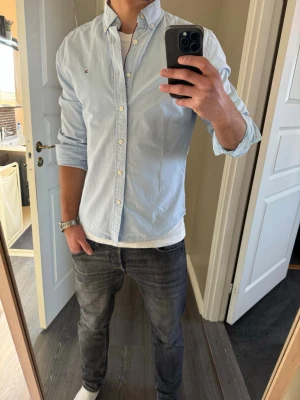 Ljusblå skjorta från Tommy Hilfiger - Klassisk ljusblå skjorta från Tommy Hilfiger, perfekt nu till våren! Storlek M slim-fit. Tveka inte att kontakta vid frågor, pris kan diskuteras 🌸