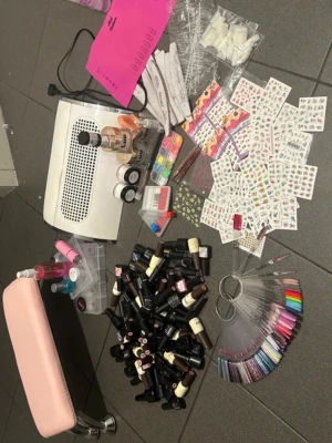 Stort nagelkit med geléer och dekorationer - Säljer ett komplett nagelkit med massor av gelélack i olika färger, nageldekorationer, stickers, nagelfilar, tippar, penslar, nagelstöd i rosa, UV-lampa och provringar för färgval. Perfekt för dig som vill fixa naglar hemma eller starta eget nagelstudio. Allt är inte nytt!