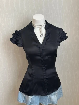 Svart satinblus med volangärmar - Tag says M but it fits more like s 