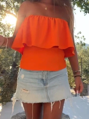 Zara orange tubtopp - Snygg orange axelbandslös tubtopp med volangdetalj. Köptes förra året och ej använd då den är för stor i midjan för mig så säljer därav, kostade 400 orgpris🤍