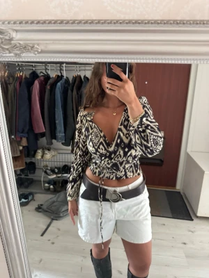 Mango Tie-Front Blouse – Adjustable Waist & Buttoned Sleeves – Size M - Soft and feminine blouse from Mango featuring a flattering tie-front design that you can adjust for the perfect fit.  The lightweight fabric and subtle cream/multi tones give it an effortless, elegant feel while still keeping it versatile for everyday wear. Button details on the sleeves add a polished touch.   OBS ‼️: as you can se in the picture on the on the left shoulder it’s a ripped part. In my opinion it makes it cooler and more unique, but be aware