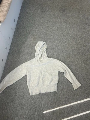 Ljusgrå stickad hoodie med huva - En stickad hoodie från Gina yong bra kvalité använd få gånger