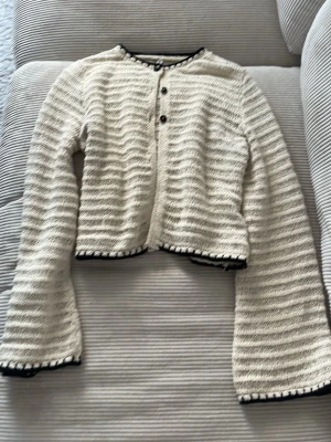 Beige  ribbad kofta med svarta detaljer - Beige, broderad kofta med svarta knappar och svarta detaljer 