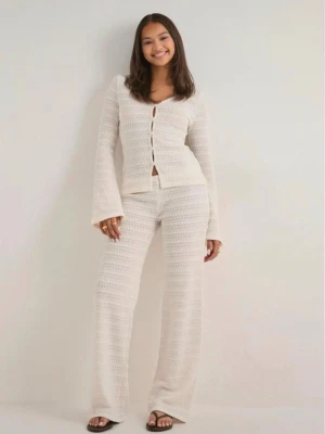 Vitt virkat loungewear-set från Nelly - Säljer ett vitt virkat loungewear-set från Nelly med långärmad cardigan och matchande byxor. Cardiganen har v-ringning, knappar framtill och vida ärmar. Setet är mjukt och luftigt, perfekt för chill dagar hemma.