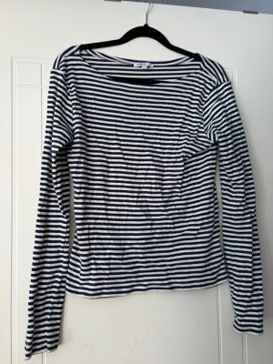 Randig långärmad topp i bomull - Söt långärmad randig topp ifrån Subdued. Den har ”Boat neck” och passar bra till alla möjliga tillfällen. Storlek M