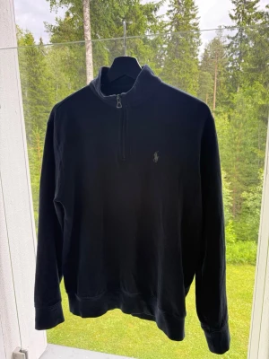 Svart halvzip från Polo Ralph Lauren - Klassisk svart långärmad tröja från Polo Ralph Lauren med halv dragkedja. Tröjan är använd fåtal gånger och har nu blivit för liten, storlek S. Nypris runt 2300kr 