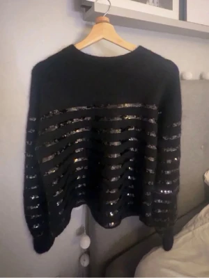 Tröja från & Other stories  - Skön svart tröja med paljett ränder syns på bild 1&3, säljer då jag aldrig använder, strl s men passar mig med xs, den är avklippt längsned som syns på bild 3 men man ser knappt o tänker absolut inte på det, förhandling kan ske! ställ frågor 🥰
