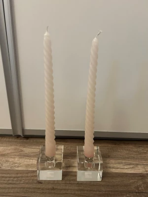 Två ljuslyktor i glas från Gina Tricot  - Två Crystal s candle holder Clear i klarglas från Gina Tricot. Lyktorna har en fyrkantig design, perfekta som dekoration till hemmet. Observera att ljusen inte följer med utan är för demonstration. 