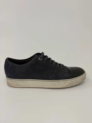 Mörkgrå sneakers med lackad tå - Snygga mörkgrå sneakers med ovandel i mocka och svart lackad tå. Skorna har vita sulor med lätt sliten look och matchande mörkgrå skosnören. Perfekta för dig som gillar en stilren men ändå unik sneaker.