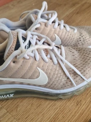 Beige Nike Air Max sneakers - Säljer ett par beige Nike Air Max sneakers med vit sula och vit swoosh. Ovandelen är i meshmaterial för bra andningsförmåga och skorna har vita skosnören. Synlig Air Max-dämpning i sulan för extra komfort. Perfekta för dig som gillar sportig och stilren look.