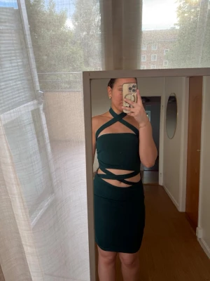 Mörkgrön cut out klänning - Mörkgrön  kort klänning med flera cut out-detaljer och halterneck. 