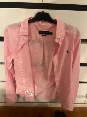 Rosa skjorta från Ralph Lauren - Ljusrosa linne/tunn skjorta från Ralph lauren. Skicka 10/10 passar ej. Snabb affär=bättre pris 🤝 passar S liten i storleken