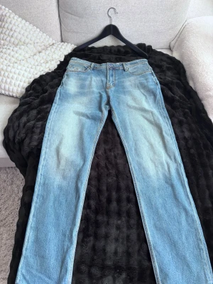  Jacob Cohen Jeans Bard - Säljer ett par ljusblå jeans från Jacob Cohen med raka ben och klassisk femficksmodell. Jeansen har snygga slitningar och en vintage tvätt som ger en avslappnad look. Tillverkade i denim med skinnpatch bak i midjan. Använd ett fåtal gånger.
