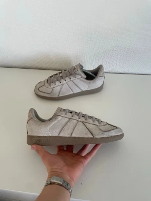 Beige Adidas Gats - Snygga beige gats från  Adidas. Skorna har ton-i-ton snörning, diskret Adidas-logga på sidan och gummisula. Perfekta för en clean och stilren look.