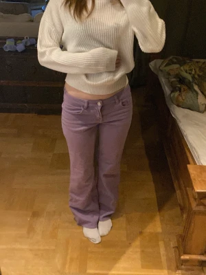 Lila bootcut jeans med låg midja - Säljer ett par lila jeans med bootcut-modell och låg midja. Jeansen har klassiska fickor fram och bak. 