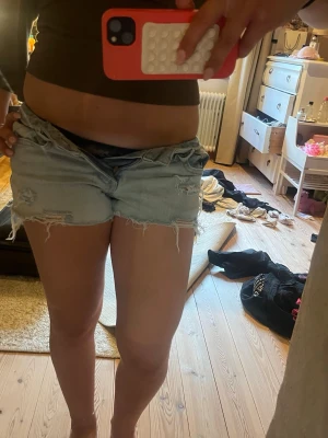 Ljusblå slitna jeansshorts - ljusblå jeansshorts, avklippta jeans, tyvärr passar dom inte mig