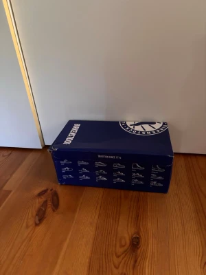 Beige mockatofflor från Birkenstock - Säljer ett par snygga beige tofflor från Birkenstock i mjuk mocka. Klassisk slip-in modell med justerbart spänne och korksula för extra komfort. Perfekta för dig som vill ha både stil och bekvämlighet hemma eller på språng.