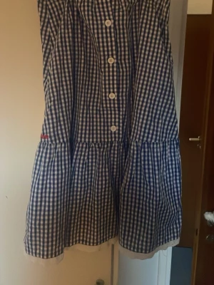 Blårutig klänning med knappar - Super söt rutig kjol. Ger lite Madicken känsla. Står ej storlek men gissar på ca xs