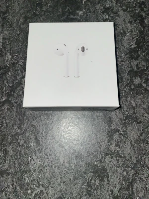 Apple AirPods med trådlöst laddningsetui - Säljer helt nya AirPods som aldrig använts. Förpackningen är oöppnad och allt är original. Perfekta för musik, samtal och vardagsanvändning. Laddfodral ingår.