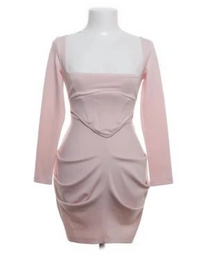 Ljusrosa kort klänning med drapering - Trendig ljusrosa kort klänning med långa ärmar och fyrkantig urringning. Klänningen har markerad midja, draperade detaljer framtill och en figurnära passform. Perfekt för dig som gillar en feminin och modern stil.