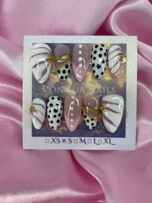 Bijou (S);Medium Almond - Handgjorda Press-on naglar i storlek S: 15 mm, 11,5 mm, 12 mm, 11 mm, 9 mm . Setet har medium mandelform och mixar rosa, vit och svart med prickar, swirl-mönster och gulddekor. Designen är både lekfull och elegant med detaljer som guldlinjer och kontrasterande färger.