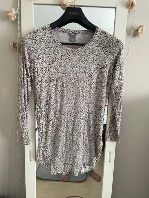 Långärmad prickig topp från Lindex - Snygg långärmad topp från Lindex med svartvitt prickigt mönster. Tunn och mjuk i materialet, perfekt för lager-på-lager eller som den är. Rund halsringning och normal passform. Enkel att styla till både jeans och kjol.storlek är xs men den är som smal och medium 