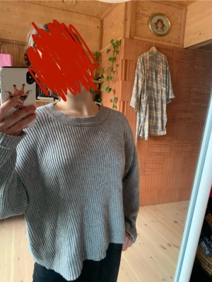 Grå ribbad långärmad tröja - Säljer en grå ribbad långärmad tröja med avslappnad passform och rund hals. Tröjan har ett enkelt och stilrent utseende, perfekt för dig som gillar en chill och basic look. Materialet känns mjukt och bekvämt mot huden. Tröjan är från bik bok. 