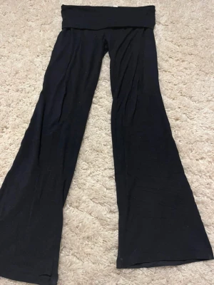 Yogabyxor - Säljer ett par Yogabyxor med utsvängda ben och bred linning i midjan. Mjukt och stretchigt material som sitter skönt på kroppen. Perfekta för en avslappnad och trendig look.