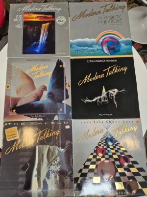 Modern Talking LP-album samling - Samling med sex LP-album av Modern Talking. Omslagen har färgstarka motiv med bland annat vattenfall, duvor, regnbågar och grafiska mönster. Albumen är från 80-talet och har klassiska pop- och synthomslag. Perfekt för fans av retro och musiknostalgi.