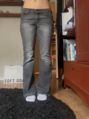Grå bootcut jeans  - Snygga grå bootcut jeans med lätt slitna detaljer och klassisk femficksdesign. Snygga gråa levisjeans! Lågmidjade/midwaist, bootcut. Inga defekter/hål. Passar storlek 34/36.  Midjemått: 37 cm tvärs över Innerbenslängd: 75 cm Fotändan: 24 cm 