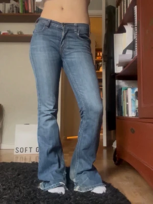 Blå bootcut jeans med låg midja - Jättesnygga bootcutjeans, ” vintage 70’s flare”, midwaist/lowwaist i en snygg mellanblå färg. Från Levis!! Sjukt snygg passform. En aning slitna vid hälen, se sista bilden. Waist 25. Sitter som en 36:a/ storlek S. Midjemått: 37 cm rakt över Innerbenslängd: 83 cm Fotändan: 27 cm