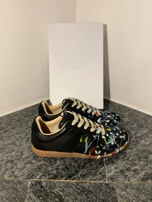 Maison Margiela Gats - Svarta Maison Margiela paint splatter. Helt nya! Priset är inte fast. Kom privat för flera frågor!