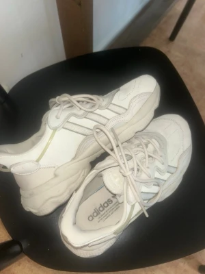 Vita Adidas sneakers med chunky sula - Säljer ett par vita Adidas sneakers med chunky sula och klassiska tre ränder på sidan. Skorna har lågt skaft och är tillverkade i en mix av läder och textil. Perfekta för en sportig och trendig look.