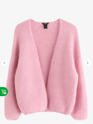 Ljusrosa stickad cardigan - Mysig ljusrosa stickad cardigan med öppen front och lång ärm. Tröjan har en loose passform och är perfekt för lager på lager. Enkel och stilren design utan knappar eller dragkedja.