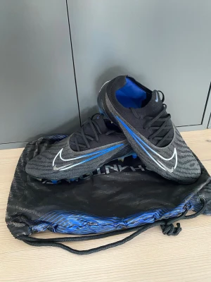 Nike Phantom Elite SG - Tjena, säljer ett par Nike Phantom Elite i väldigt fint skick. Storlek 41,5 och nypris på ca 3000kr. Mitt pris 899kr, hör av er vid frågor!