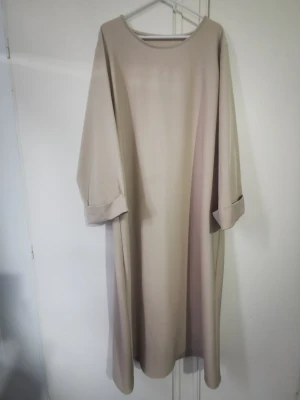 Beige abaya med vida armar  - 127 cm lång beige abaya är i storlek M/L