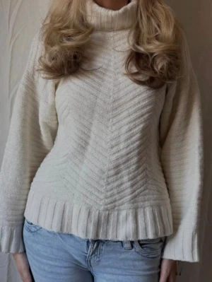 Vit stickad polotröja - Säljer en beige/benvit stickad polotröja med bred ribbstickad krage